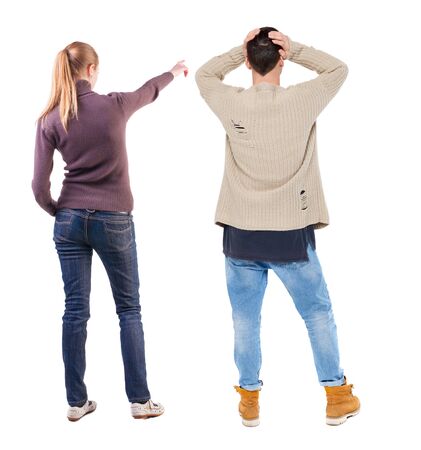 Back view of couple couple in sweater pointing. beautiful friendly girl and guy together. Rear view people collection. backside view of person. Isolated over white background.の写真素材