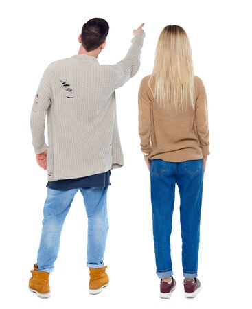 Back view of couple couple in sweater pointing. beautiful friendly girl and guy together. Rear view people collection. backside view of person. Isolated over white background.の写真素材