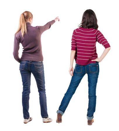 Back view of two pointing young girl in sweater. Rear view people collection. backside view of person. beautiful woman friends showing gesture. Rear view. Isolated over white background.の写真素材