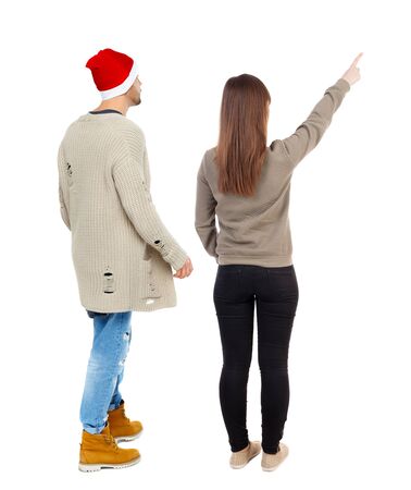 Back view of couple couple in sweater pointing. beautiful friendly girl and guy together. Rear view people collection. backside view of person. Isolated over white background.の写真素材