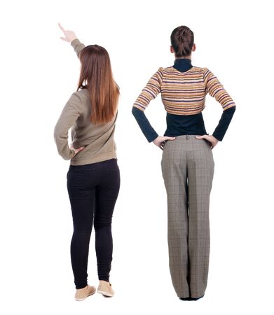 Back view of two pointing young girl in sweater. Rear view people collection. backside view of person. beautiful woman friends showing gesture. Rear view. Isolated over white background.の写真素材