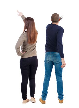 Back view of couple couple in sweater pointing. beautiful friendly girl and guy together. Rear view people collection. backside view of person. Isolated over white background.の写真素材