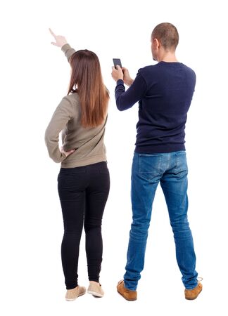 Back view of couple in sweater with mobile phone. beautiful friendly girl and guy together. Rear view people collection. backside view of person. Isolated over white background.の写真素材
