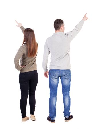 Back view of couple couple in sweater pointing. beautiful friendly girl and guy together. Rear view people collection. backside view of person. Isolated over white background.の写真素材