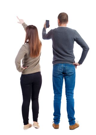 Back view of couple in sweater with mobile phone. beautiful friendly girl and guy together. Rear view people collection. backside view of person. Isolated over white background.の写真素材
