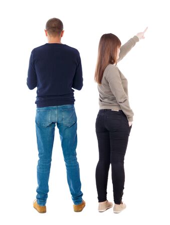 Back view of couple couple in sweater pointing. beautiful friendly girl and guy together. Rear view people collection. backside view of person. Isolated over white background.の写真素材