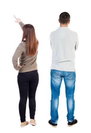 Back view of couple couple in sweater pointing. beautiful friendly girl and guy together. Rear view people collection. backside view of person. Isolated over white background.の写真素材