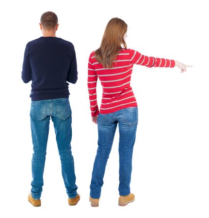 Back view of couple couple in sweater pointing. beautiful friendly girl and guy together. Rear view people collection. backside view of person. Isolated over white background.の写真素材
