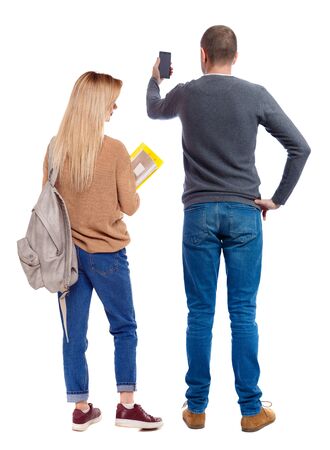 Back view of couple in sweater with mobile phone. beautiful friendly girl and guy together. Rear view people collection. backside view of person. Isolated over white background.の写真素材