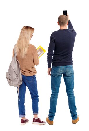 Back view of couple in sweater with mobile phone. beautiful friendly girl and guy together. Rear view people collection. backside view of person. Isolated over white background.の写真素材