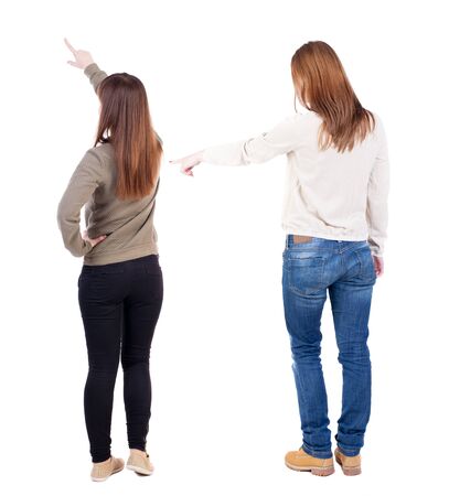 Back view of two pointing young girl in sweater. Rear view people collection. backside view of person. beautiful woman friends showing gesture. Rear view. Isolated over white background.の写真素材