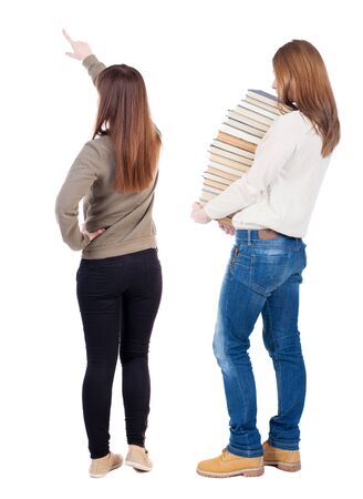 Back view of two pointing young girl in sweater. Rear view people collection. backside view of person. beautiful woman friends showing gesture. Rear view. Isolated over white background.の写真素材