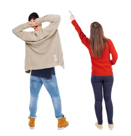 Back view of couple couple in sweater pointing. beautiful friendly girl and guy together. Rear view people collection. backside view of person. Isolated over white background.の写真素材