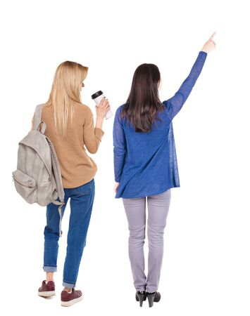 Back view of two pointing young girl in sweater. Rear view people collection. backside view of person. beautiful woman friends showing gesture. Rear view. Isolated over white background.の写真素材
