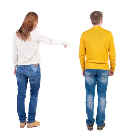 Back view of couple couple in sweater pointing. beautiful friendly girl and guy together. Rear view people collection. backside view of person. Isolated over white background.の写真素材