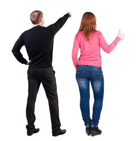 Back view of couple couple in sweater pointing. beautiful friendly girl and guy together. Rear view people collection. backside view of person. Isolated over white background.の写真素材