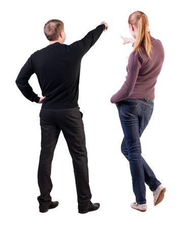 Back view of couple couple in sweater pointing. beautiful friendly girl and guy together. Rear view people collection. backside view of person. Isolated over white background.の写真素材