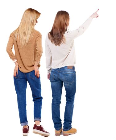 Back view of two pointing young girl in sweater. Rear view people collection. backside view of person. beautiful woman friends showing gesture. Rear view. Isolated over white background.の写真素材