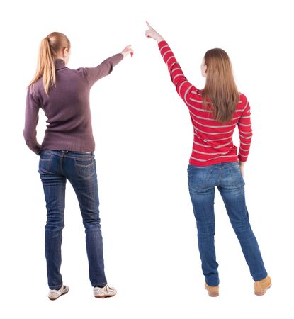 Back view of two pointing young girl in sweater. Rear view people collection. backside view of person. beautiful woman friends showing gesture. Rear view. Isolated over white background.の写真素材