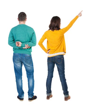 Back view of couple couple in sweater pointing. beautiful friendly girl and guy together. Rear view people collection. backside view of person. Isolated over white background.の写真素材