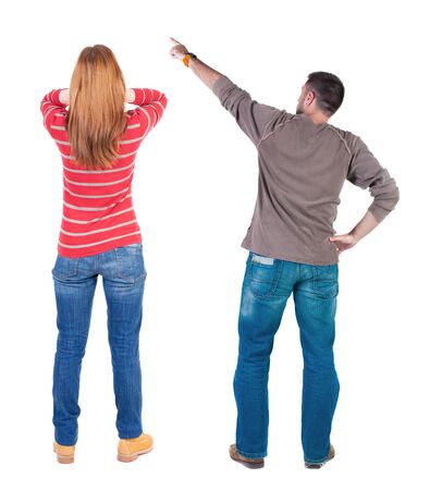 Back view of couple couple in sweater pointing. beautiful friendly girl and guy together. Rear view people collection. backside view of person. Isolated over white background.の写真素材