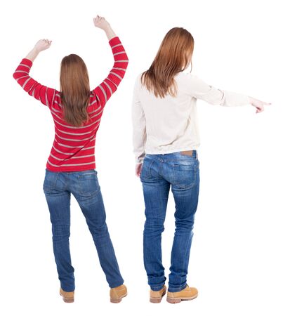 Back view of two pointing young girl in sweater. Rear view people collection. backside view of person. beautiful woman friends showing gesture. Rear view. Isolated over white background.の写真素材