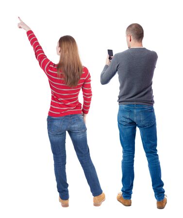 Back view of couple in sweater with mobile phone. beautiful friendly girl and guy together. Rear view people collection. backside view of person. Isolated over white background.の写真素材