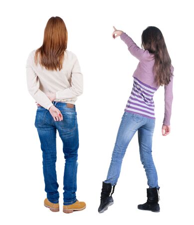 Back view of two pointing young girl in sweater. Rear view people collection. backside view of person. beautiful woman friends showing gesture. Rear view. Isolated over white background.の写真素材