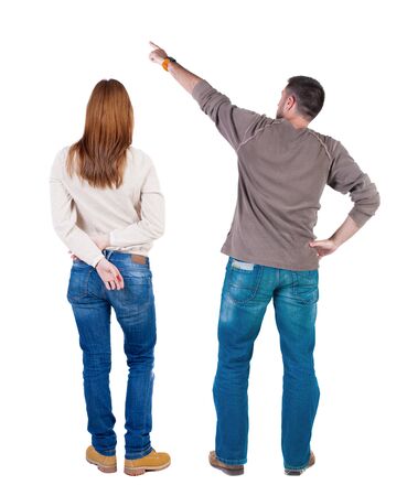 Back view of couple couple in sweater pointing. beautiful friendly girl and guy together. Rear view people collection. backside view of person. Isolated over white background.の写真素材
