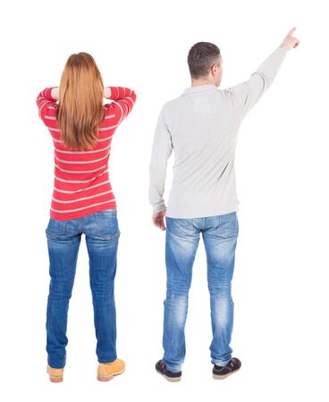 Back view of couple couple in sweater pointing. beautiful friendly girl and guy together. Rear view people collection. backside view of person. Isolated over white background.の写真素材