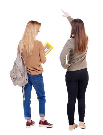 Back view of two pointing young girl in sweater. Rear view people collection. backside view of person. beautiful woman friends showing gesture. Rear view. Isolated over white background.の写真素材