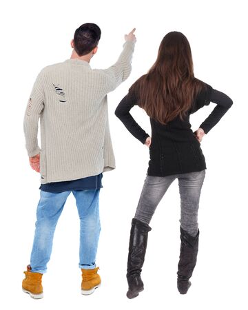 Back view of couple couple in sweater pointing. beautiful friendly girl and guy together. Rear view people collection. backside view of person. Isolated over white background.の写真素材