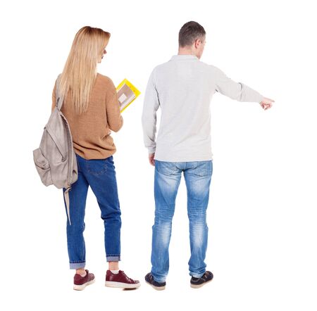 Back view of couple couple in sweater pointing. beautiful friendly girl and guy together. Rear view people collection. backside view of person. Isolated over white background.の写真素材