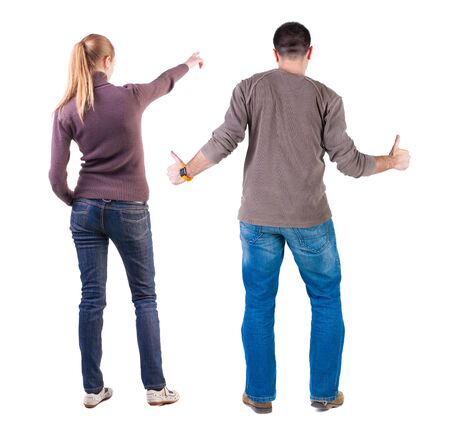 Back view of couple couple in sweater pointing. beautiful friendly girl and guy together. Rear view people collection. backside view of person. Isolated over white background.の写真素材