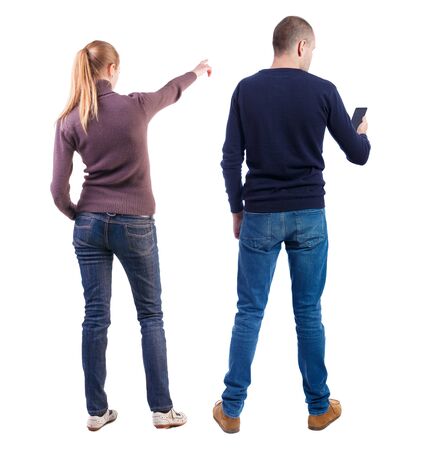 Back view of couple in sweater with mobile phone. beautiful friendly girl and guy together. Rear view people collection. backside view of person. Isolated over white background.の写真素材