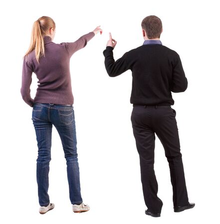 Back view of couple couple in sweater pointing. beautiful friendly girl and guy together. Rear view people collection. backside view of person. Isolated over white background.の写真素材