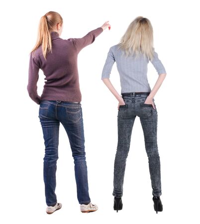 Back view of two pointing young girl in sweater. Rear view people collection. backside view of person. beautiful woman friends showing gesture. Rear view. Isolated over white background.の写真素材