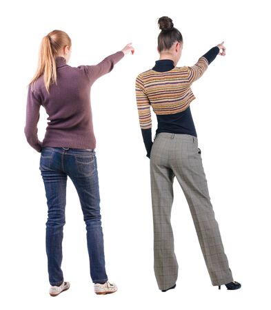 Back view of two pointing young girl in sweater. Rear view people collection. backside view of person. beautiful woman friends showing gesture. Rear view. Isolated over white background.の写真素材