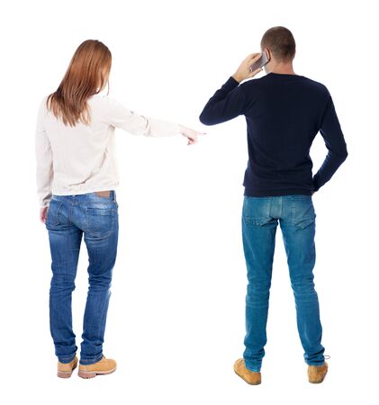 Back view of couple in sweater with mobile phone. beautiful friendly girl and guy together. Rear view people collection. backside view of person. Isolated over white background.の写真素材