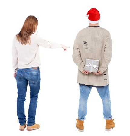 Back view of couple couple in sweater pointing. beautiful friendly girl and guy together. Rear view people collection. backside view of person. Isolated over white background.の写真素材