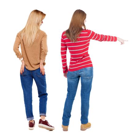 Back view of two pointing young girl in sweater. Rear view people collection. backside view of person. beautiful woman friends showing gesture. Rear view. Isolated over white background.の写真素材
