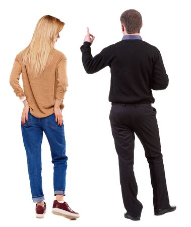 Back view of couple couple in sweater pointing. beautiful friendly girl and guy together. Rear view people collection. backside view of person. Isolated over white background.の写真素材