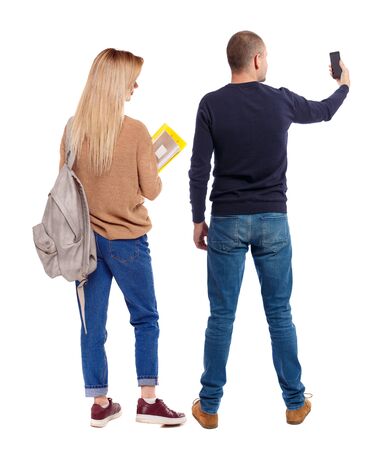 Back view of couple in sweater with mobile phone. beautiful friendly girl and guy together. Rear view people collection. backside view of person. Isolated over white background.の写真素材
