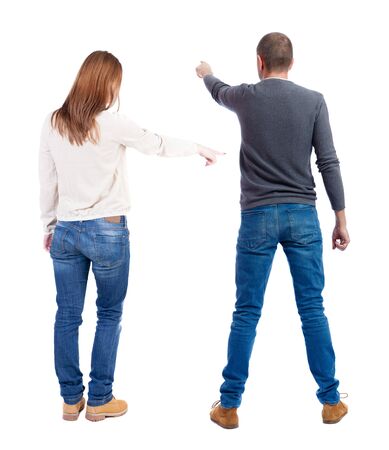 Back view of couple couple in sweater pointing. beautiful friendly girl and guy together. Rear view people collection. backside view of person. Isolated over white background.の写真素材