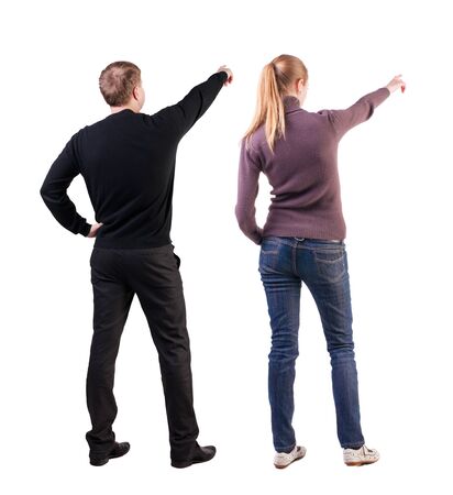 Back view of couple couple in sweater pointing. beautiful friendly girl and guy together. Rear view people collection. backside view of person. Isolated over white background.の写真素材