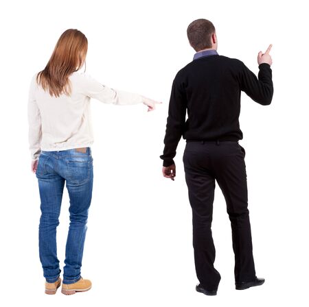 Back view of couple couple in sweater pointing. beautiful friendly girl and guy together. Rear view people collection. backside view of person. Isolated over white background.の写真素材