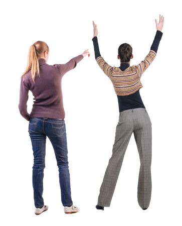 Back view of two pointing young girl in sweater. Rear view people collection. backside view of person. beautiful woman friends showing gesture. Rear view. Isolated over white background.の写真素材