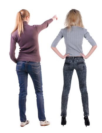 Back view of two pointing young girl in sweater. Rear view people collection. backside view of person. beautiful woman friends showing gesture. Rear view. Isolated over white background.の写真素材