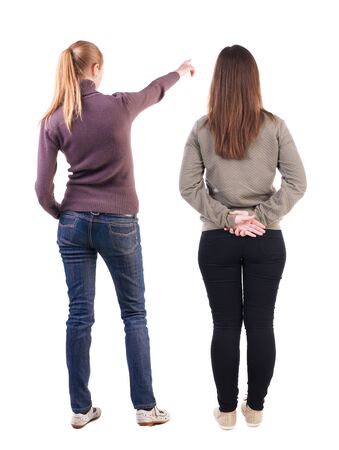 Back view of two pointing young girl in sweater. Rear view people collection. backside view of person. beautiful woman friends showing gesture. Rear view. Isolated over white background.の写真素材