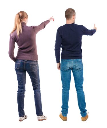 Back view of couple couple in sweater pointing. beautiful friendly girl and guy together. Rear view people collection. backside view of person. Isolated over white background.の写真素材
